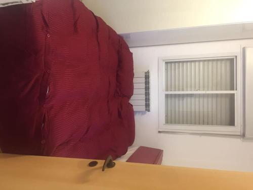 une chemise rouge assise sur une table à côté d'une fenêtre dans l'établissement Jerusalem Guest suite, à Jérusalem