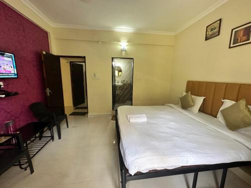 a bedroom with a large white bed in a room at Hotel Leela Inn Candolim in Marmagao