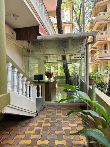a lobby of a building with a staircase with a glass door at Hotel Leela Inn Candolim in Marmagao