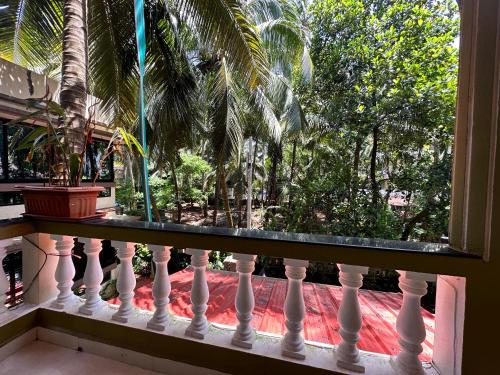 a balcony with a view of a palm tree at Hotel Leela Inn Candolim in Marmagao