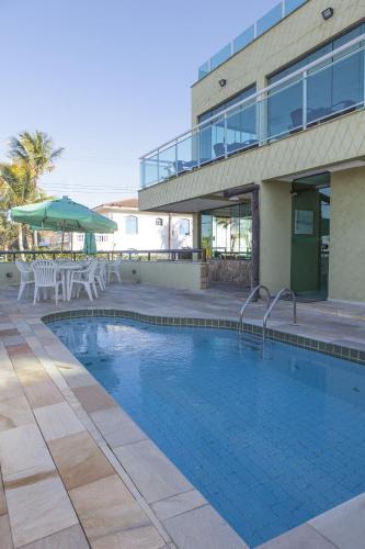 a swimming pool in front of a building at Hotel Vicino al Mare - Frente mar in Guarujá