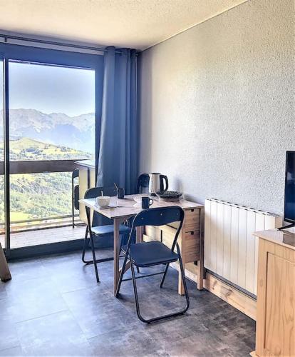 une pièce avec une table, des chaises et une fenêtre dans l'établissement Mes vacances à la montagne, à Villarembert