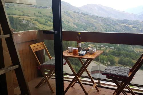 un tavolo con sedie su un balcone con una bottiglia di vino di Mes vacances à la montagne a Villarembert