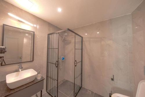 y baño con ducha, lavabo y espejo. en İstanbul City Airport Hotel en Estambul