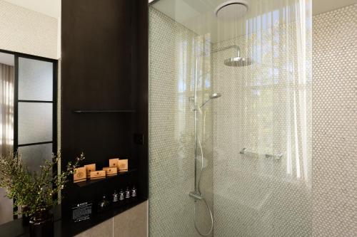 a bathroom with a shower, sink, and mirror at Coppersmith Hotel in Melbourne
