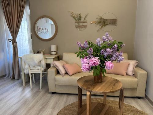 a living room with a couch and a table with purple flowers at Il Sogno in Spello
