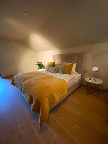 1 dormitorio con 1 cama grande con manta amarilla en Megina Lodge, en Mayen