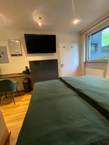 a bedroom with a bed and a flat screen tv at Zur Rotbuche in Zeltingen-Rachtig