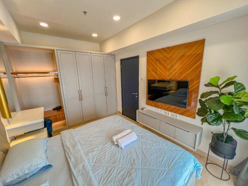 um quarto com uma cama grande e uma televisão em Brand new 2BR Empire Tower - Podomoro City em Medan