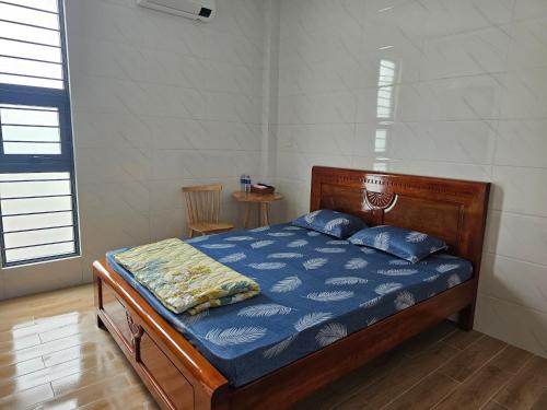 1 dormitorio con 1 cama con edredón azul en Nhà nghỉ Trúc Mây, en Ben Tre