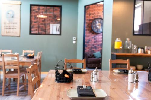 Un comedor con una mesa y sillas y un reloj. en Domaine La Grange Ungersheim - Chambres d'Hôtes L'Inspiration, en Ungersheim