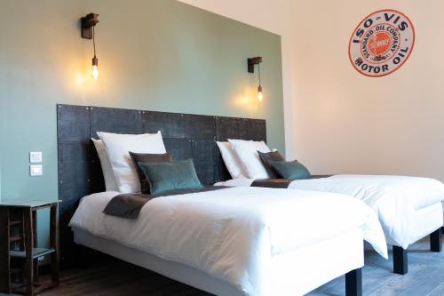 a bedroom with two beds and a sign on the wall at Domaine La Grange Ungersheim - Chambres d'Hôtes L'Inspiration in Ungersheim