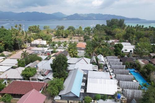 an aerial view of a town with houses and the water at Melbao Homestay in Gili Air