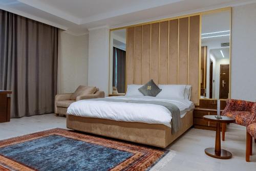 a bedroom with a bed and a couch and a chair at Sofia Hotel in Duhok