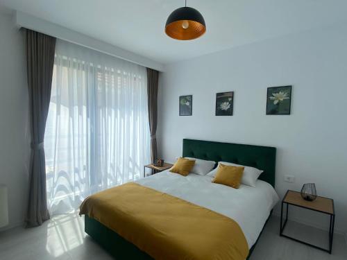 a bedroom with a bed and a large window at Vila Moga in Sînmartin