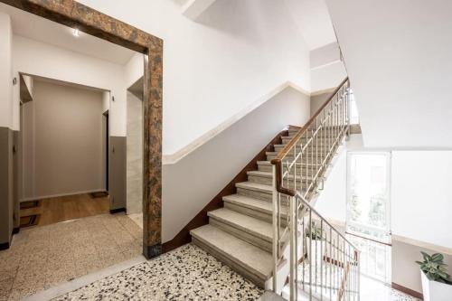 a staircase in a house with white walls and wooden beams at Cucchiari Suite 8B in Modena
