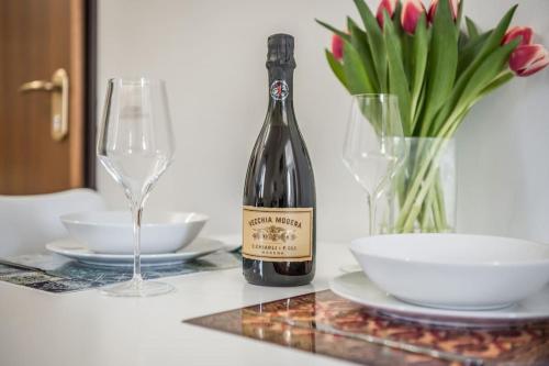 a bottle of wine sitting on a table with a glass at Cucchiari Suite 8B in Modena