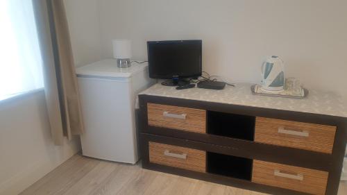 a dresser with a television and a small refrigerator at Apsley home, Hemel Hempstead in Hemel Hempstead