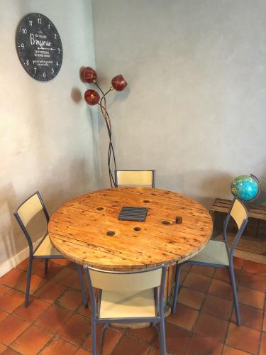 a wooden table with chairs and a laptop on it at La plage in Fécamp