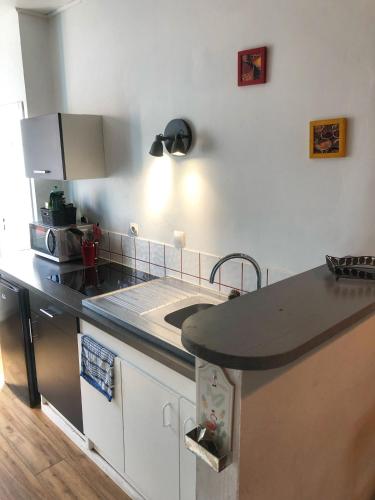 a kitchen with a sink and a counter top at La plage in Fécamp