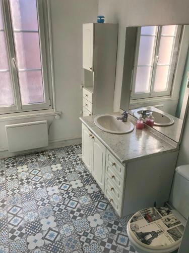 a bathroom with two sinks and a mirror at La plage in Fécamp