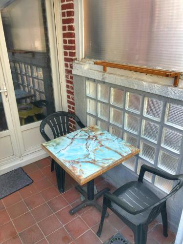 a table and a chair on a porch at La plage in Fécamp