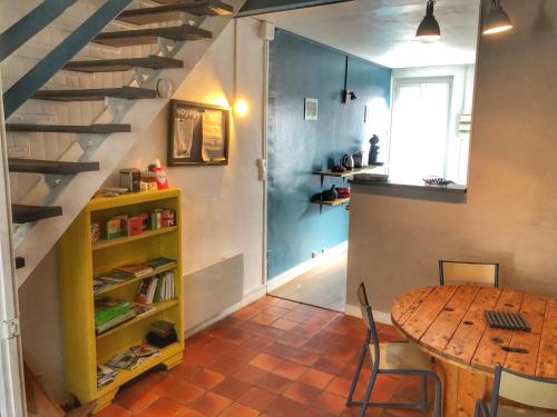a dining room with a table and a staircase at La plage in Fécamp