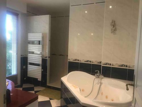uma casa de banho com banheira e piso em azulejo em VILLA LES PIEDS DANS L’EAU ACCES DIRECT A LA PLAGE em Le Plomb