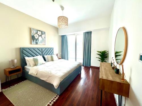 a bedroom with a bed and a mirror and a table at The Waves 241 Dubai Marina in Dubai