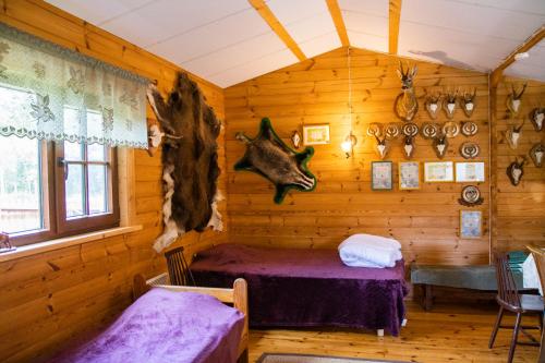 a log cabin with a bed in a room at Maarjamäe Holiday House in Räpina