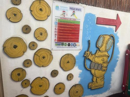 a wall with a picture of a fireman and wooden disks at Apartamentos Acuario Sol in Puerto del Carmen