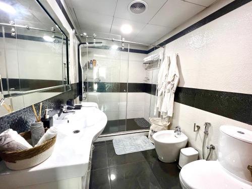 a black and white bathroom with two sinks and a toilet at The Waves 241 Dubai Marina in Dubai