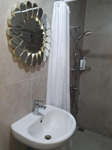 KangboiにあるLenggo - Apartement Meisterstadt Pollux Habibie 52-05の洗面台、鏡、シャワー付きのバスルーム