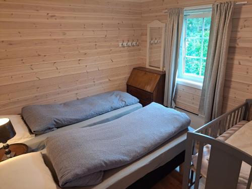 two beds in a room with a window at Nydelig hytte i Kabelvåg Lofoten in Kabelvåg