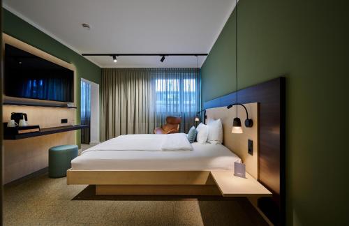 Un dormitorio con una cama grande y una pared verde en Hotel Westend en Núremberg