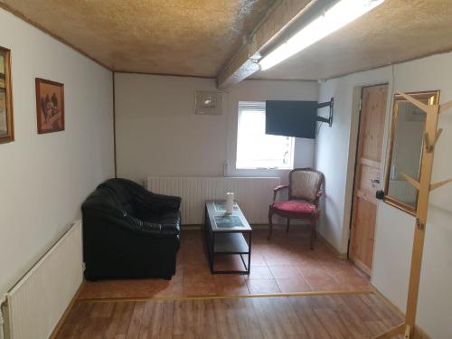 uma sala de estar com um sofá e uma mesa em Cozy Hideaway - Rustic Charm & Outdoor Adventure 1 em Hornsyld