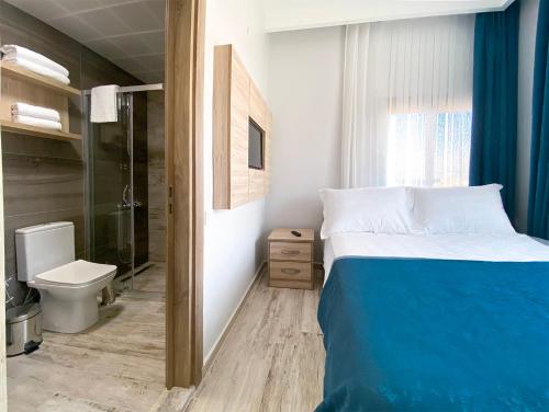 a bedroom with a bed and a shower and a toilet at eYLÜL 16 OTEL in Çeşme