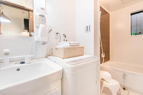 a white bathroom with a sink and a toilet at 桜の宿 高田 provide two free bicycle in Kyoto