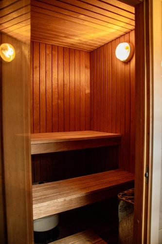 a sauna with wood paneled walls and two lights at Maarjamäe Holiday House in Räpina