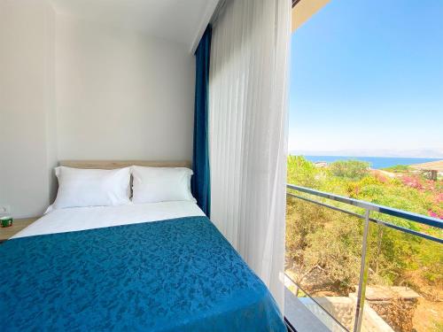 a bedroom with a bed and a balcony with a view at eYLÜL 16 OTEL in Çeşme