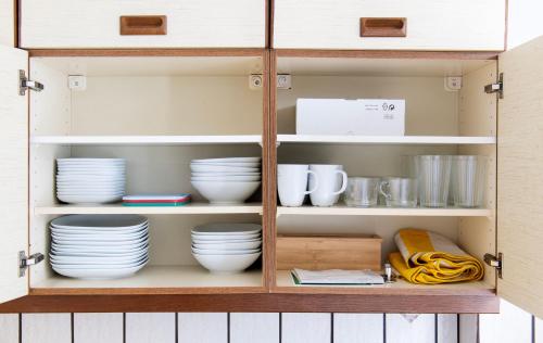 a cupboard with plates and dishes in it at City Center Apartment Kleve in Kleve
