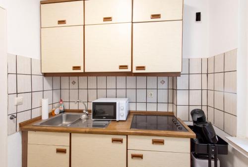 a small kitchen with a sink and a microwave at City Center Apartment Kleve in Kleve