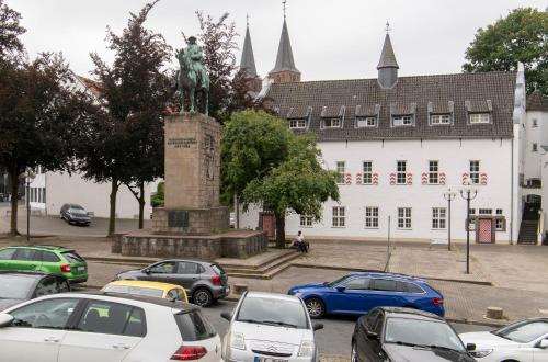 a parking lot with a statue in front of a building at City Center Apartment Kleve in Kleve