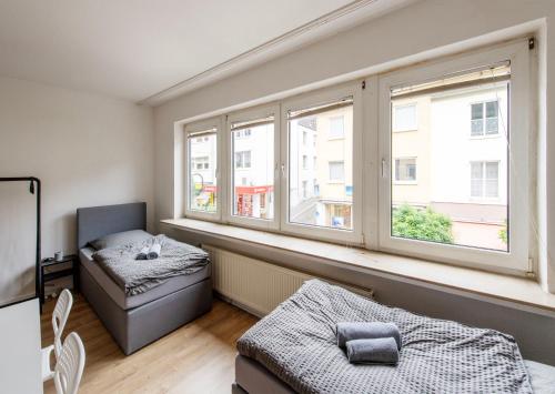 uma sala de estar com um sofá e duas janelas em City Center Apartment Kleve em Kleve