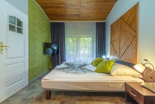 a bedroom with a bed with a wooden headboard and a window at Apartamenty Amber in Rewal