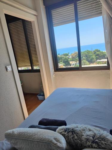 a bedroom with a large bed and two windows at El Paraiso in Aguadulce
