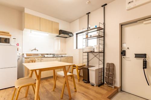 a kitchen and dining room with a table and chairs at 佐賀インターナショナルゲストハウスHAGAKURE 2号店 in Saga