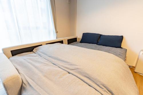 a bedroom with two beds in front of a window at 佐賀インターナショナルゲストハウスHAGAKURE 2号店 in Saga