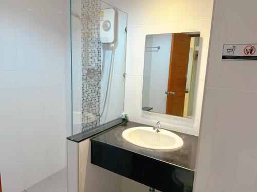 een badkamer met een wastafel en een spiegel bij Ahad Suite Ao Nang By Ma in Ao Nang Beach