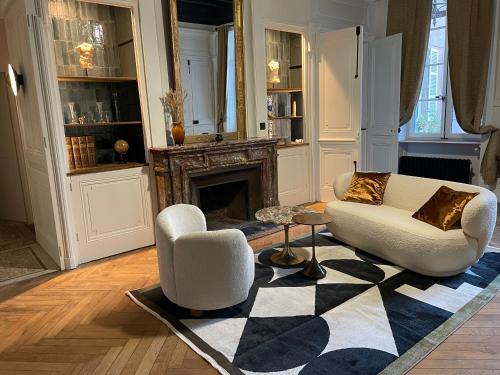 - un salon avec deux chaises et une cheminée dans l'établissement Appartement chic et de caractère !, à Saint-Cyr-au-Mont-dʼOr